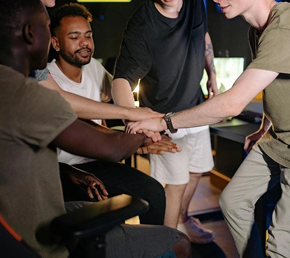 Egy e-sport csapat összekulcsolva alkot csapatmunkát a játékteremben, egységet és együttműködést mutatva a verseny előtt.