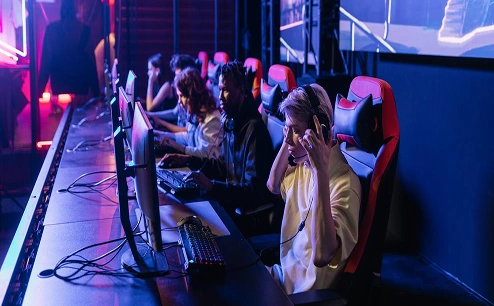 Esport csapat versenyez a színpadon egy játékversenyen, ahol több játékos PC-ket és headseteket használ.
